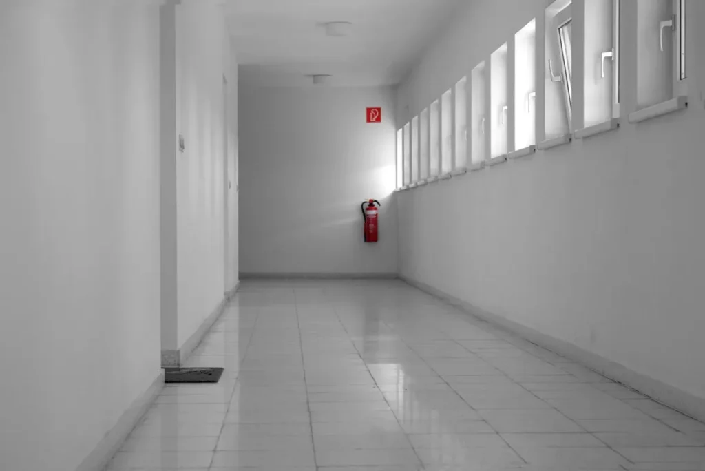 Building hallway with a wall-mounted fire extinguisher checked on a fire watch patrol